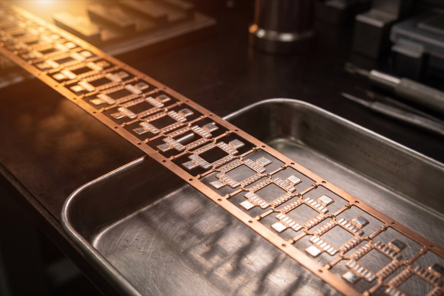 Copper lead frame strip, stamped and plated, on a stainless steel tray